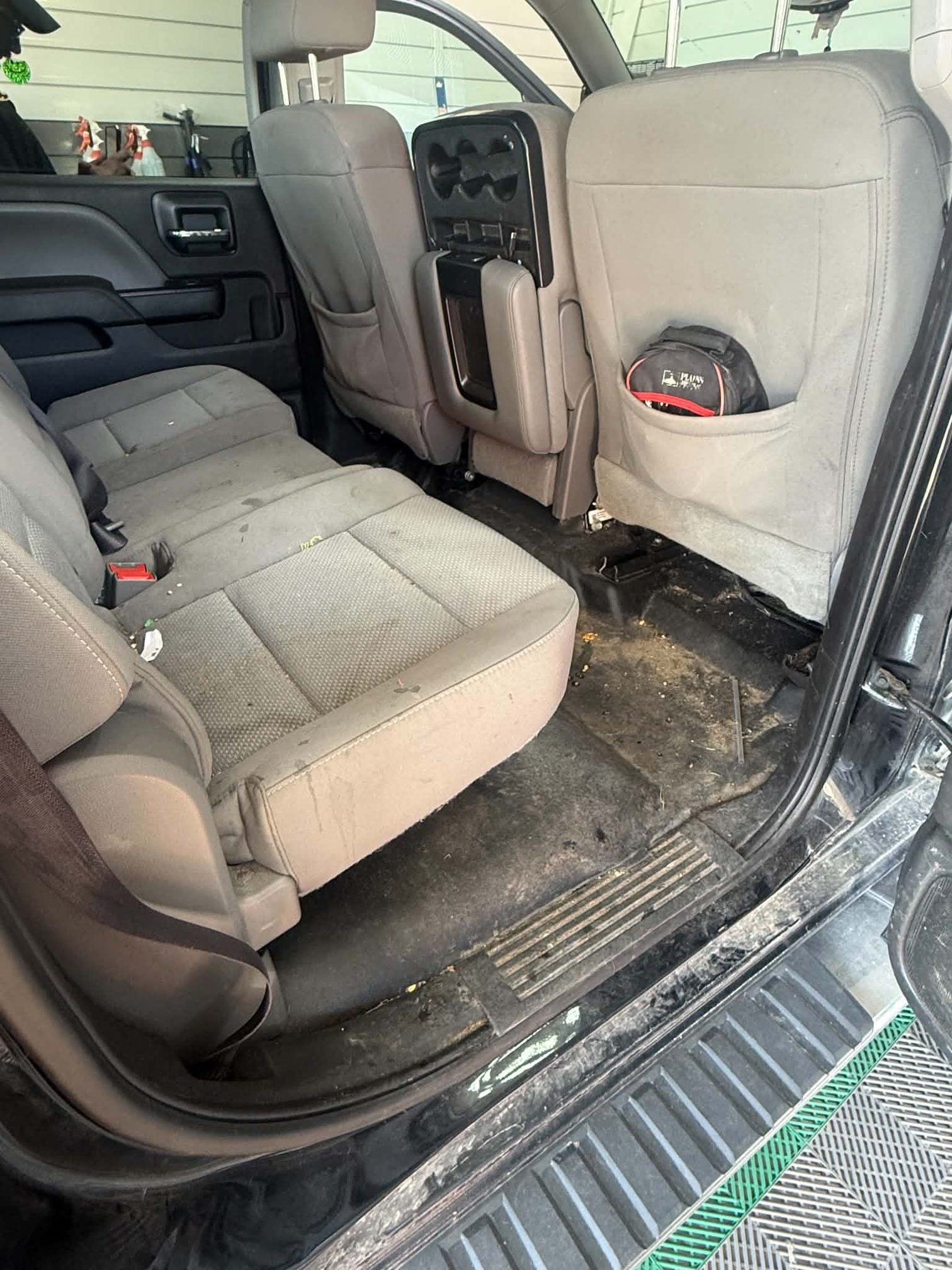 Chevrolet Silverado rear bench seat and floor before detailing, visible dirt and debris